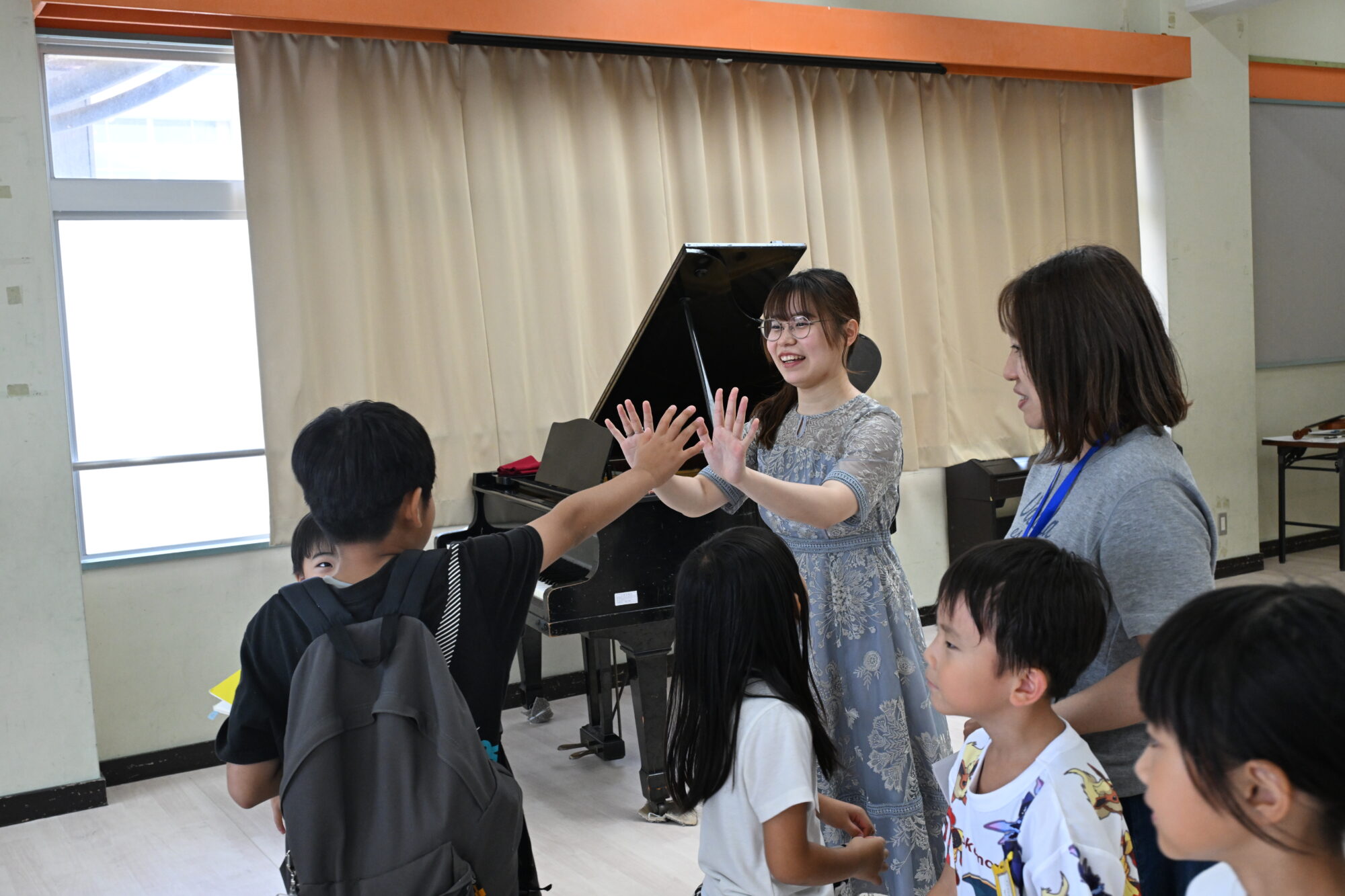 筌口和実さんが児童の皆さんとハイタッチをする様子